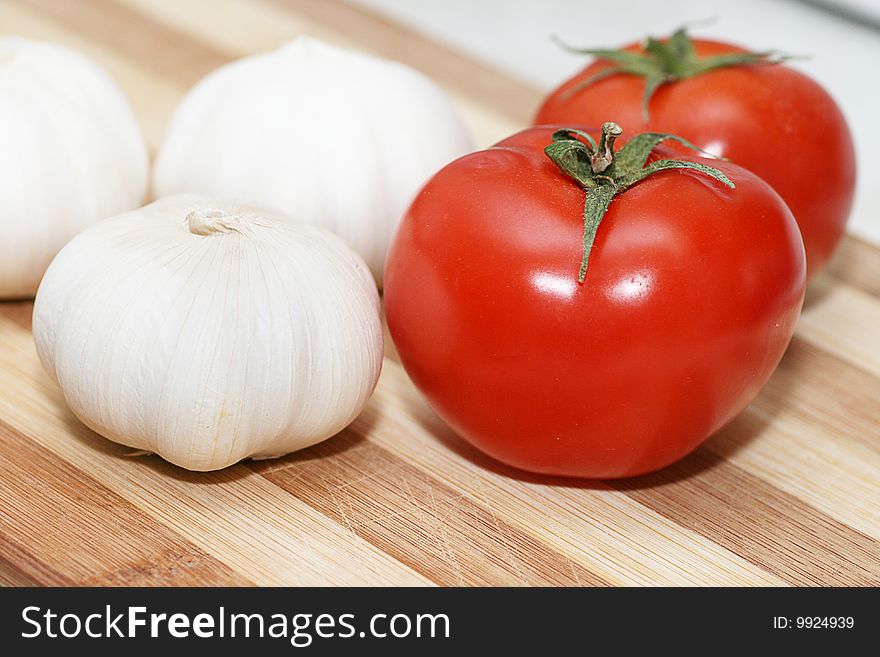 Fresh tomatoes and garlic on a chopping board