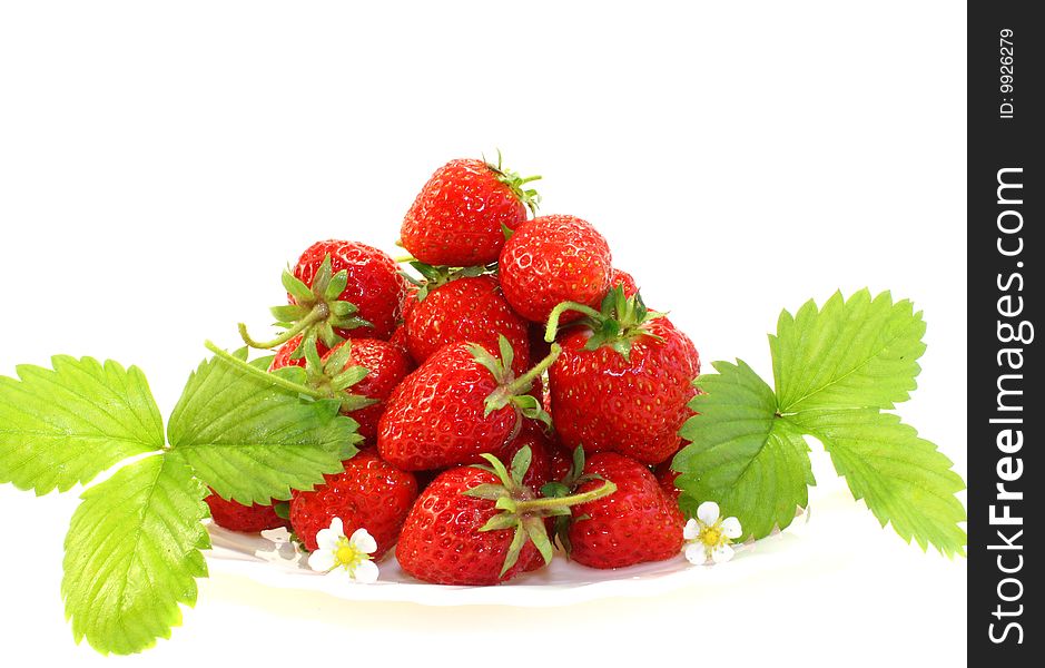 Ripe strawberry on a plate, with leaves, on a white background, it is isolated.