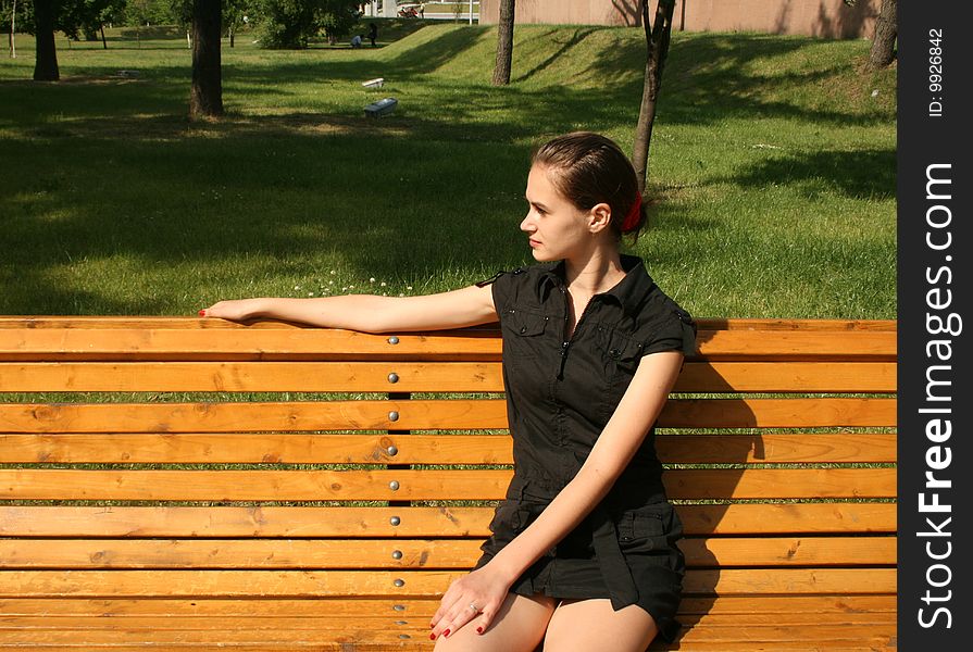 Pretty girl sitting on bench in a park