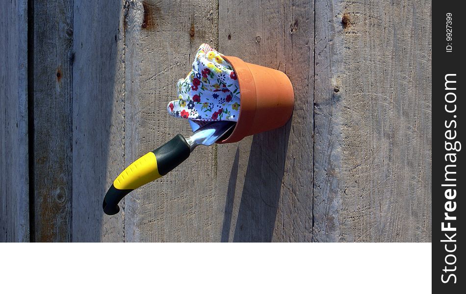 Hand garden tool in clay pot with patterned work gloves. Hand garden tool in clay pot with patterned work gloves