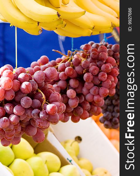 Fresh fruit on a market - grapes, banana and apples