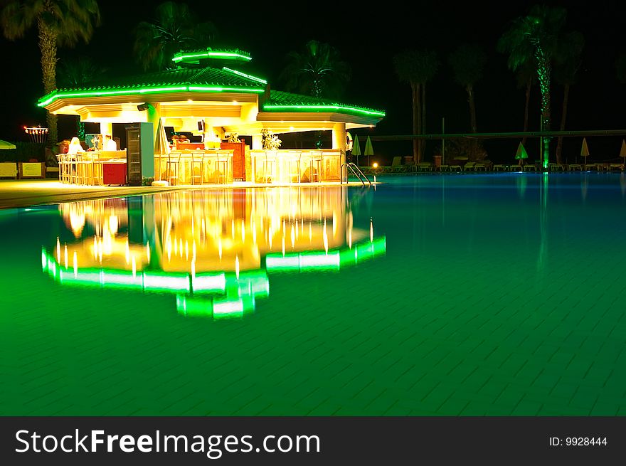 Night time photo of a swimming pool at a tropical resort