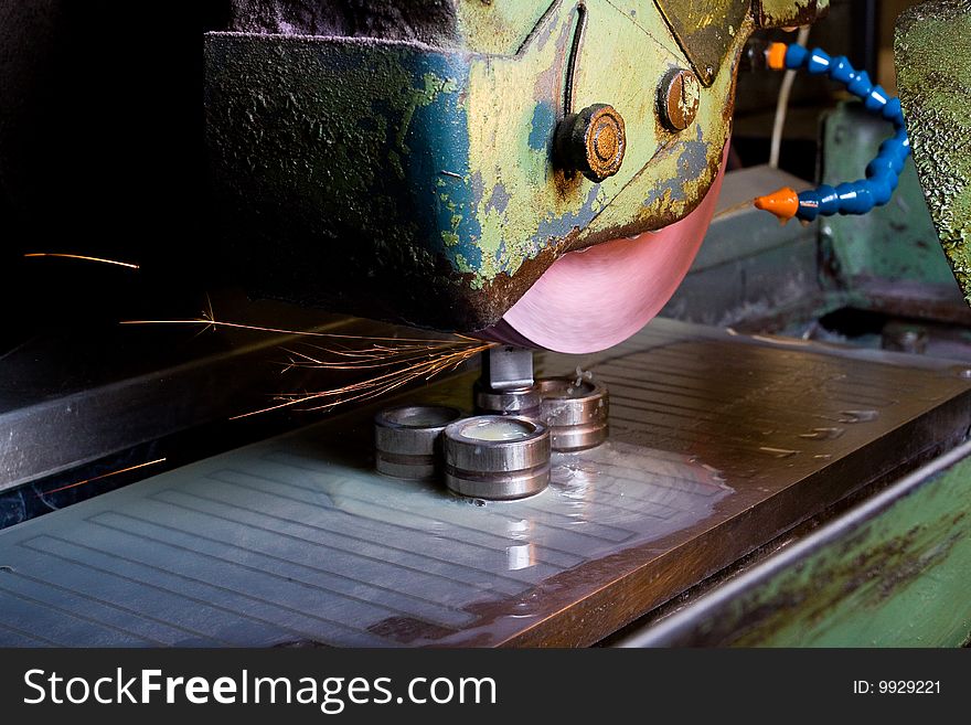 Filing down stainless steel parts using semi-automated machinery. Filing down stainless steel parts using semi-automated machinery