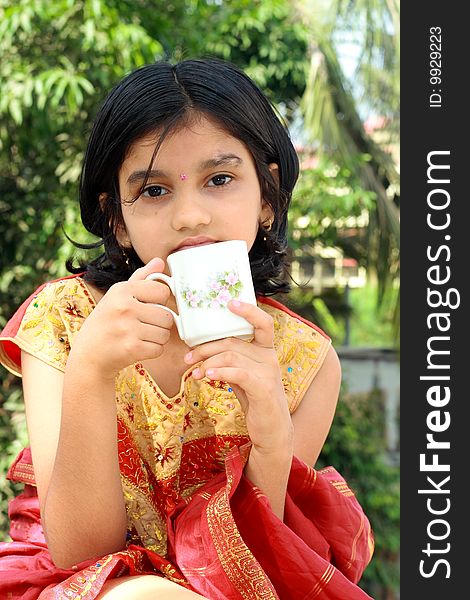 A small Indian girl having a morning tea.