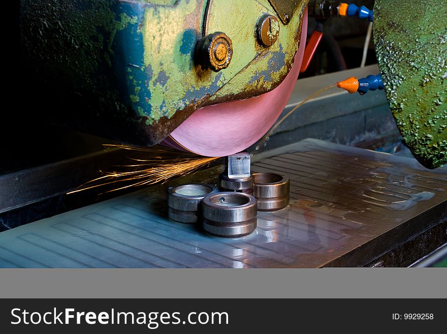 Filing down stainless steel parts using semi-automated machinery. Filing down stainless steel parts using semi-automated machinery