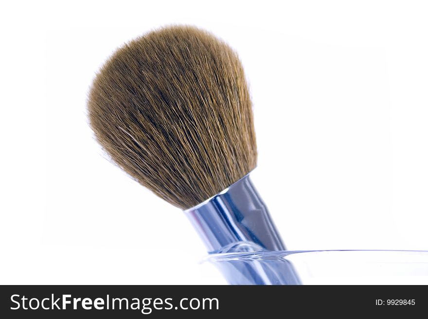 Big make-up brush in a glass. Isolated on white background.