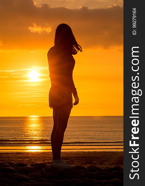 Yoga Woman doing yoga pose outside in sunset setting outdoors