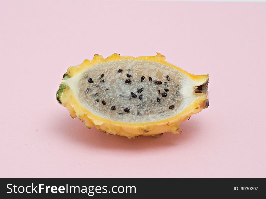 Yellow dragon fruit  section isolated on pink background