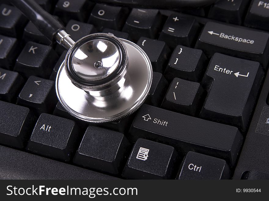 Black color computer keyboard with stethoscope on top. Black color computer keyboard with stethoscope on top.