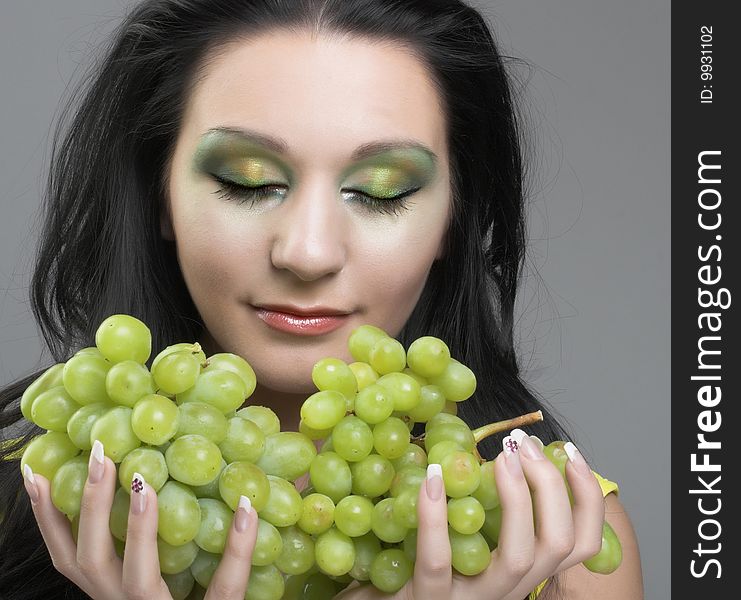 Portrait of young brunette with green grapes. Portrait of young brunette with green grapes