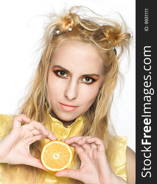 Young girl in yellow dress with piece of orange. Young girl in yellow dress with piece of orange