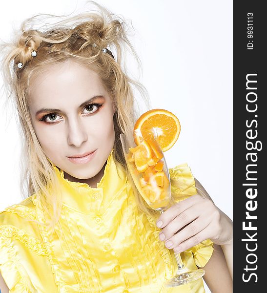 Young girl in yellow dress with piece of orange. Young girl in yellow dress with piece of orange