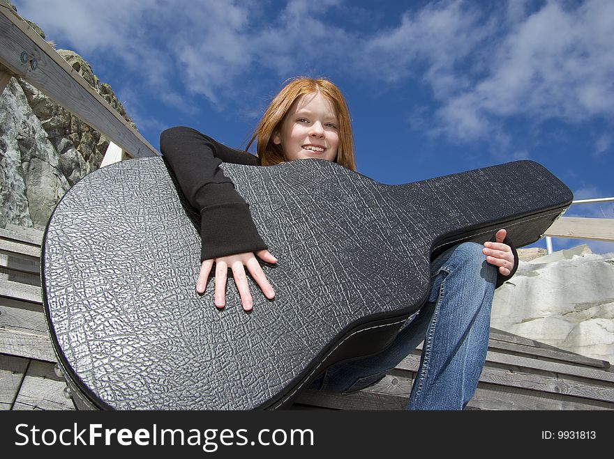 Tween girl holding guitar in its case. Tween girl holding guitar in its case