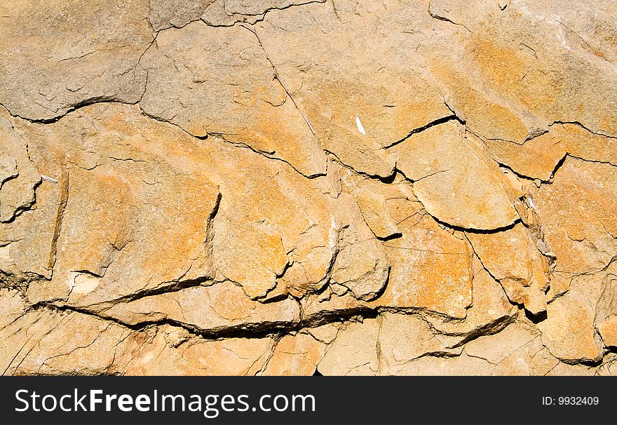 A strongly cracked yellow background of stone. A strongly cracked yellow background of stone