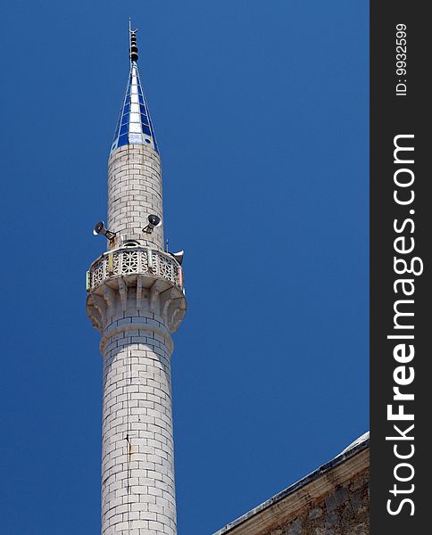 The minaret tower of a muslim mosque in turkey with a blue tip. Speakers for call to prayer. The minaret tower of a muslim mosque in turkey with a blue tip. Speakers for call to prayer.