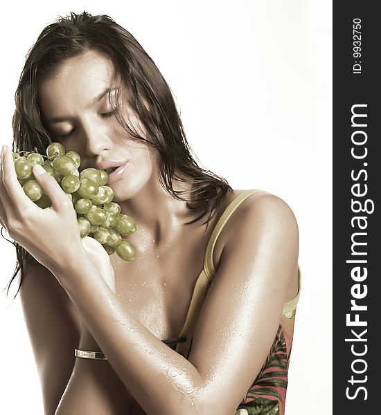 Beautiful young woman with green grape