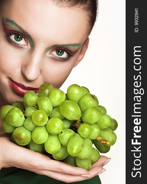 Beautiful young woman with green grape