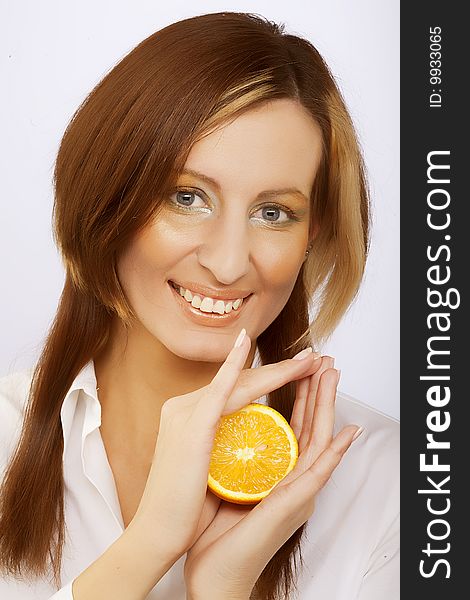 Beautiful cheerful woman with fresh orange near her face