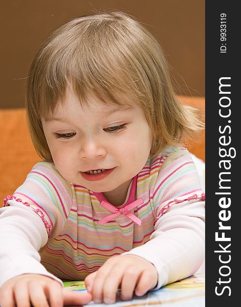 Sweet toddler baby girl reading book