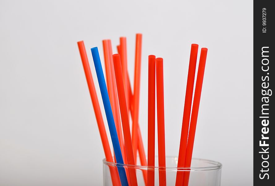 Blue straw among red straws. Blue straw among red straws