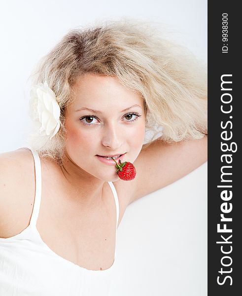 Young woman in white dress eating strawberries