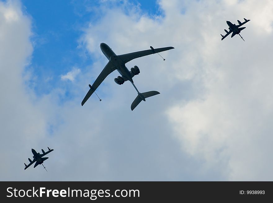 One big and two small planes against the blue sky and white clouds. One big and two small planes against the blue sky and white clouds