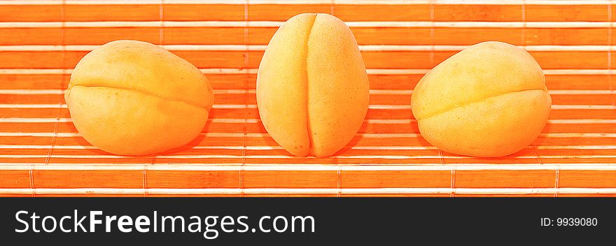 3 apricots on an orange background