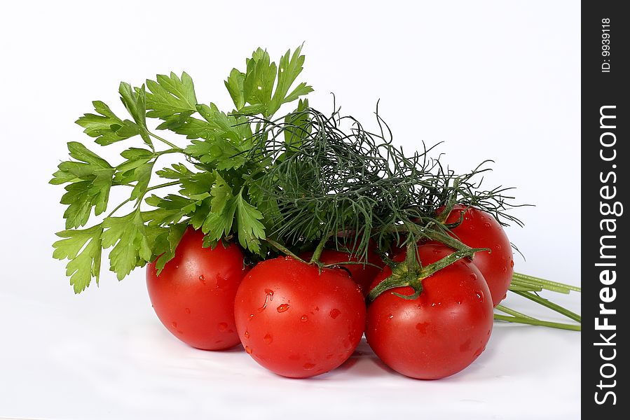 Some juicy tomatoes and greens bunches on a white background. Some juicy tomatoes and greens bunches on a white background