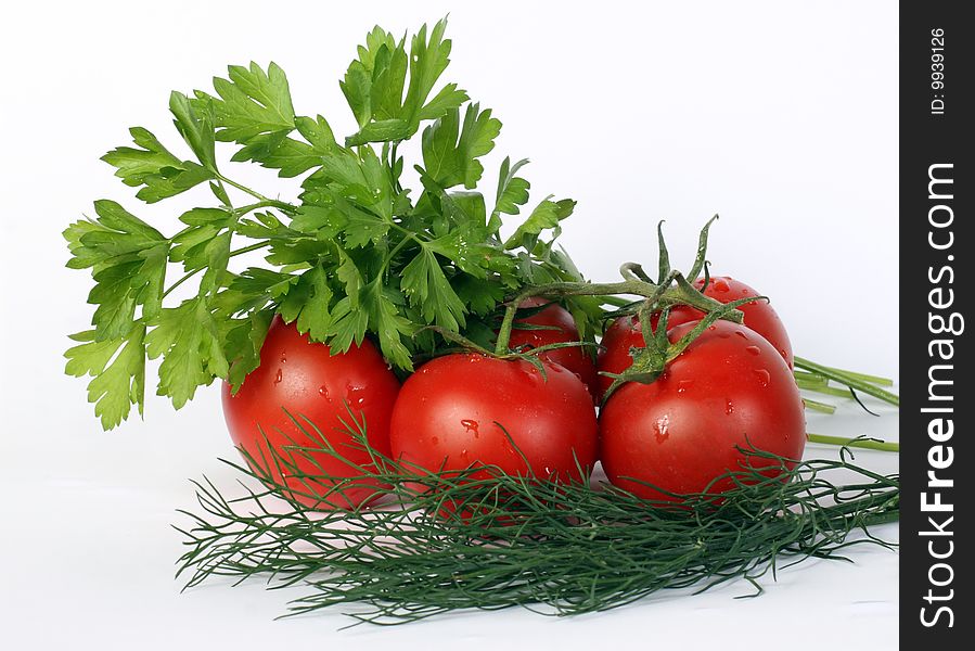 Some juicy tomatoes and parsley leaves on a white background. Some juicy tomatoes and parsley leaves on a white background