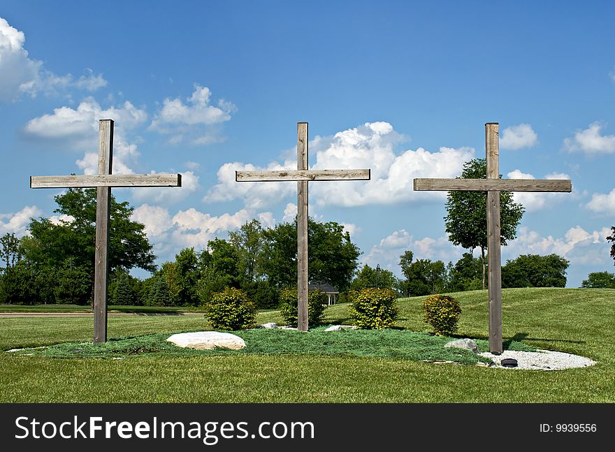 Three wooden crosses stand as Christian symbols of Jesus Christ's crucifixion at Calvary. Three wooden crosses stand as Christian symbols of Jesus Christ's crucifixion at Calvary.