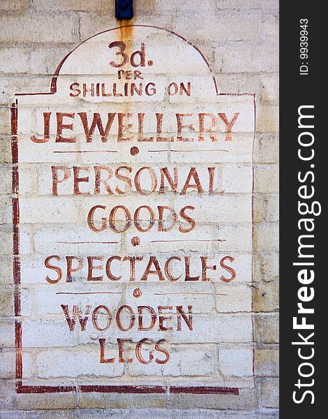 Old fashioned sign for a pawnbroker, requiring jewellery, personal goods, spectacles and wooden legs