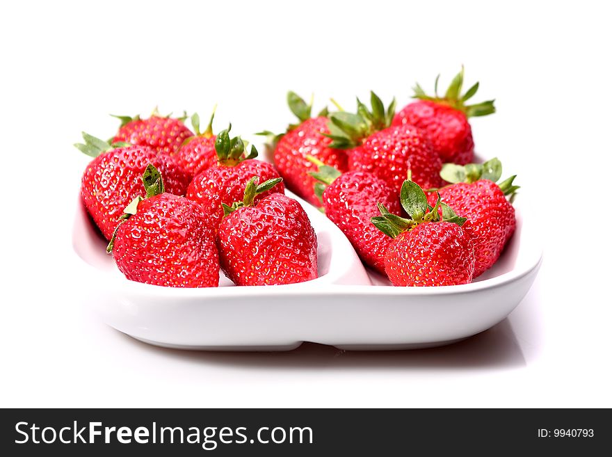 Strawberries in a white dish on a white background