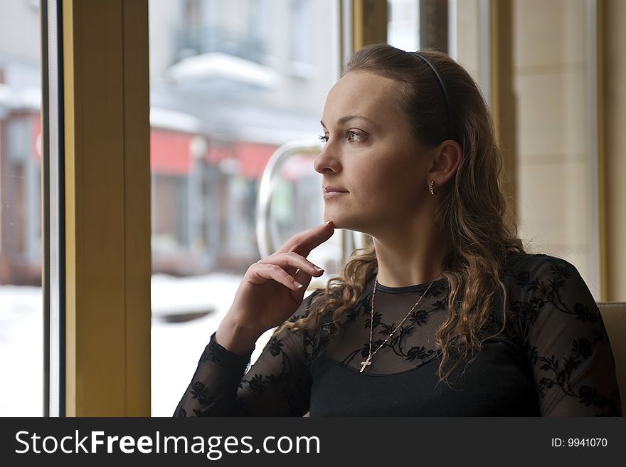 Girl sitting near the window in the restaurant. Girl sitting near the window in the restaurant