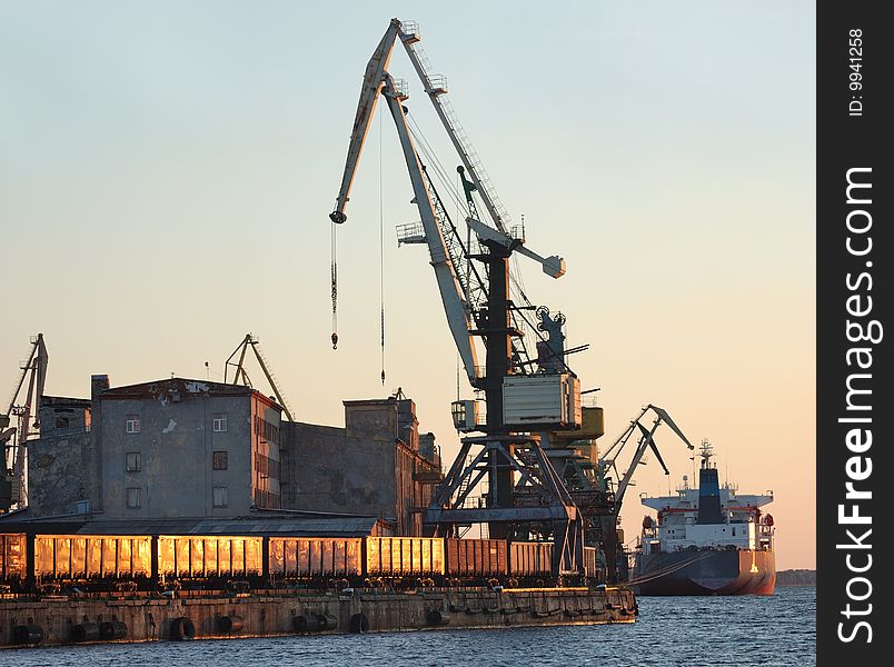 The cargo ship is loaded by coal in Riga port.