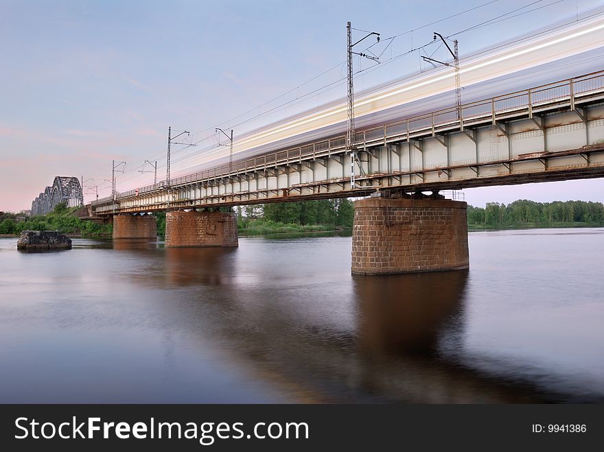 The moving express train on the bridge across Daugava river. The moving express train on the bridge across Daugava river.