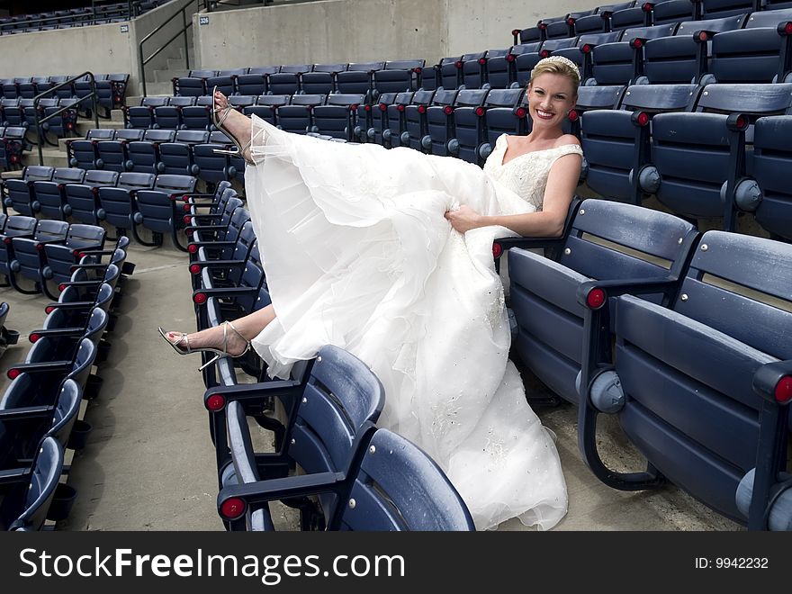 Model wearing wedding gown posed in a baseball stadium. Model wearing wedding gown posed in a baseball stadium.