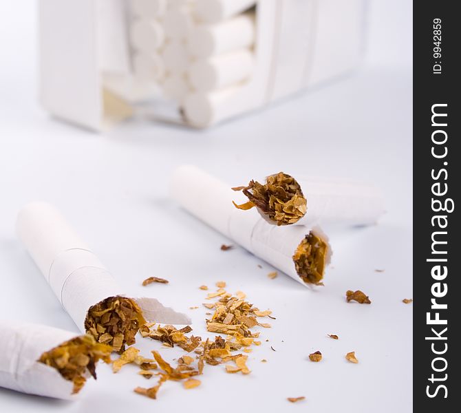 Broken cigarettes on white background