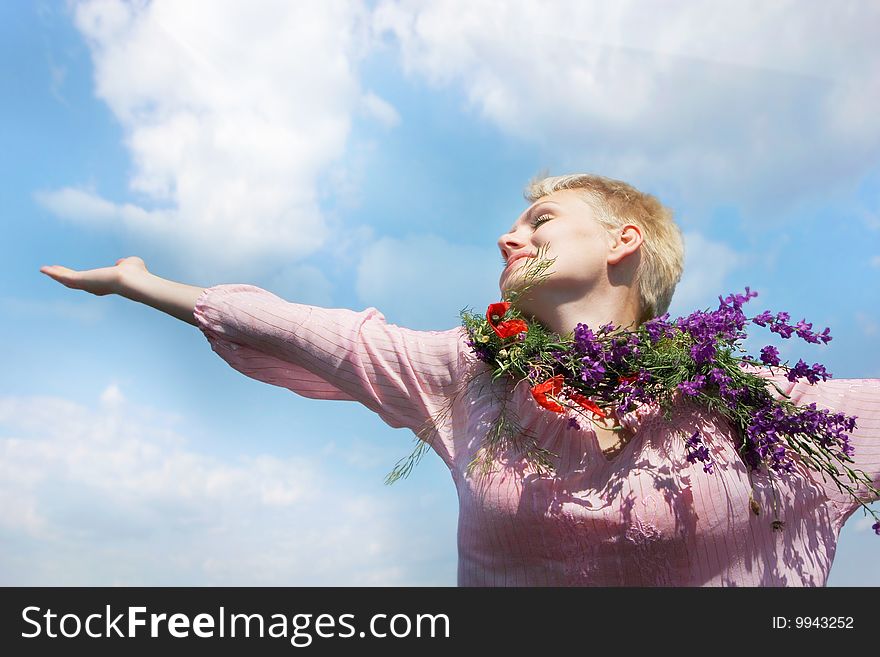 Happy girl in sun rays on sky background