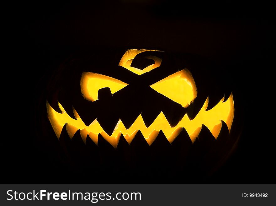 Jack-o'-lantern, spooky Halloween pumpkin face glowing in the night