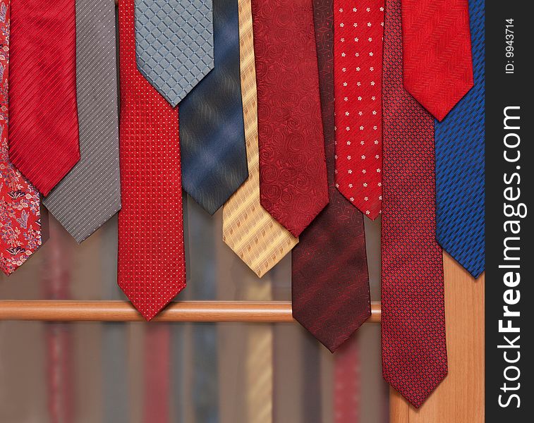 Male varicoloured ties hung on wooden door. Male varicoloured ties hung on wooden door