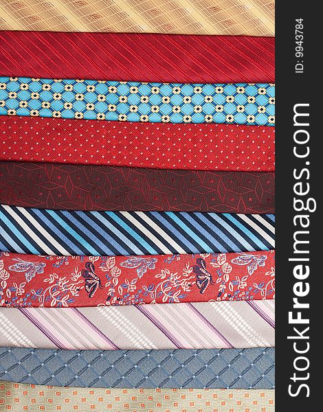 Varicoloured silk ties are put in row, macro. Varicoloured silk ties are put in row, macro