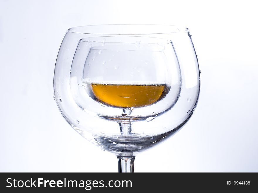 Shot of two empty glasses and one glass with wine. Shot of two empty glasses and one glass with wine.