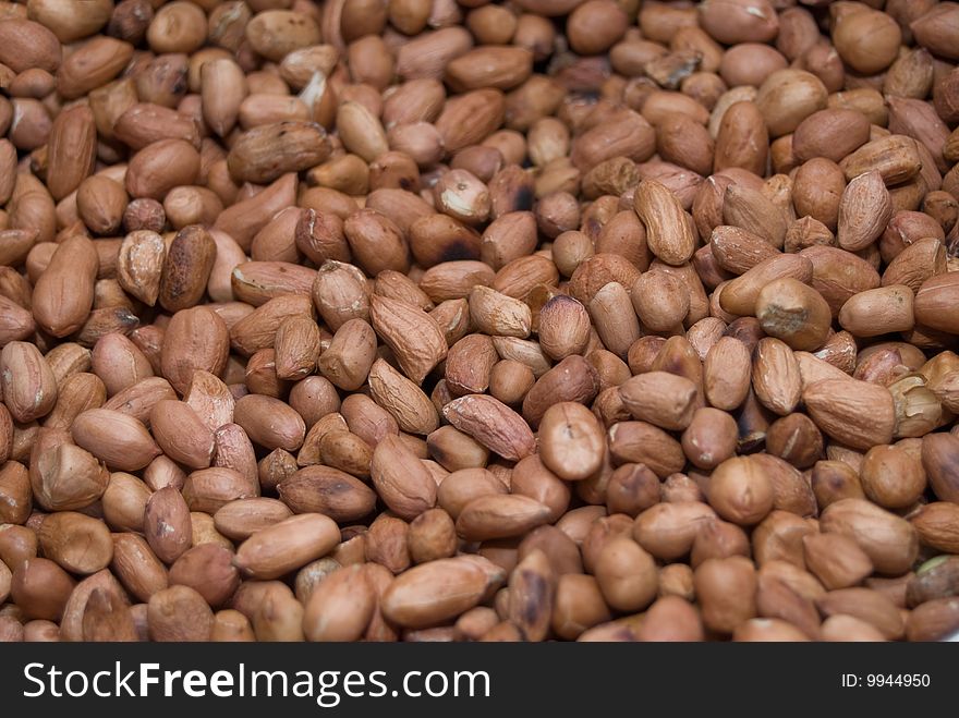 Many peanuts close up, brown background. Many peanuts close up, brown background