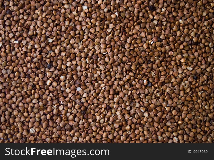 Brown buckwheat groats, diet product background. Brown buckwheat groats, diet product background