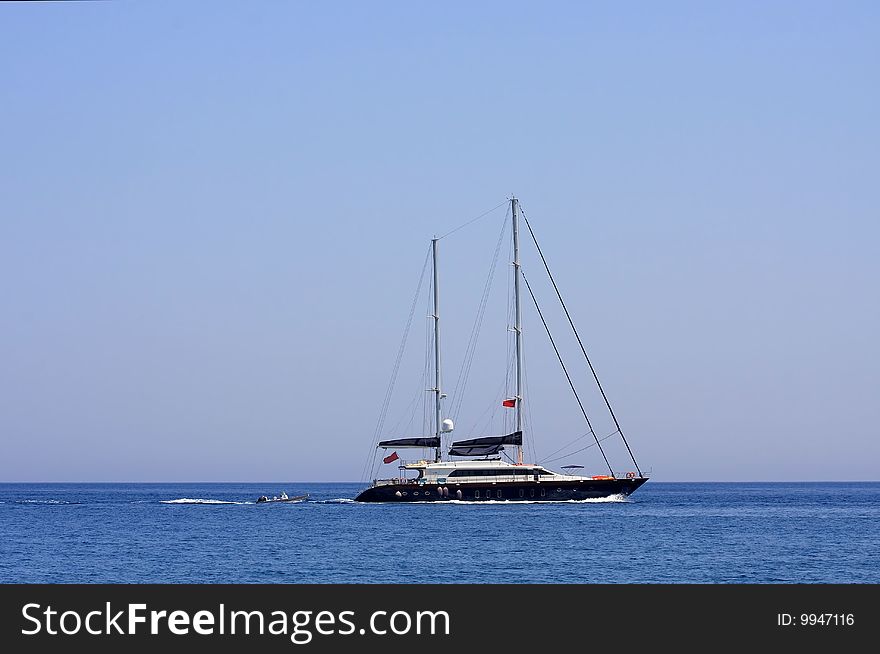 White sailboat floating on the blue sea