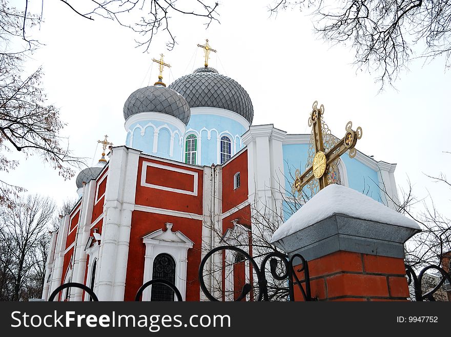 Orthodox church in a frame of trees against the sky.