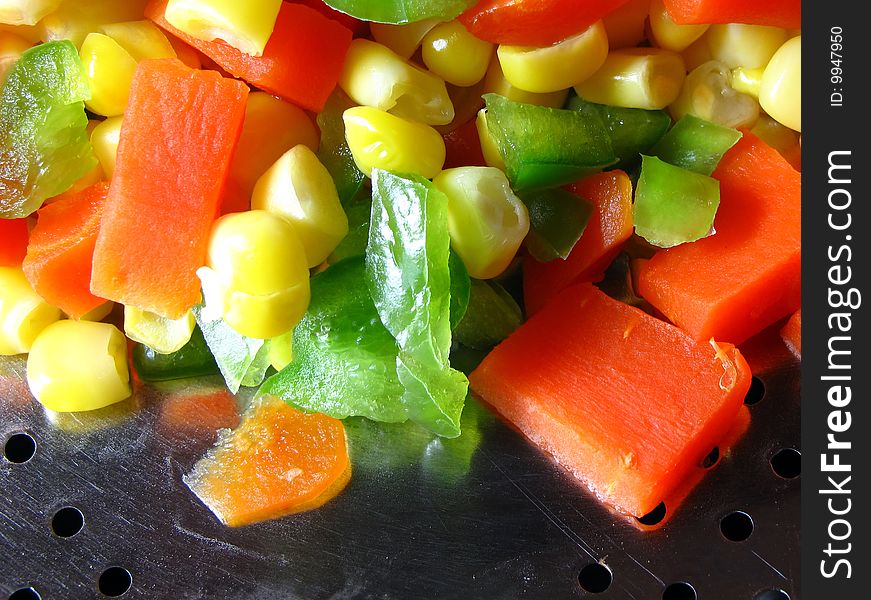Chopped carrot and green pepper with corn seeds in strainer. Chopped carrot and green pepper with corn seeds in strainer