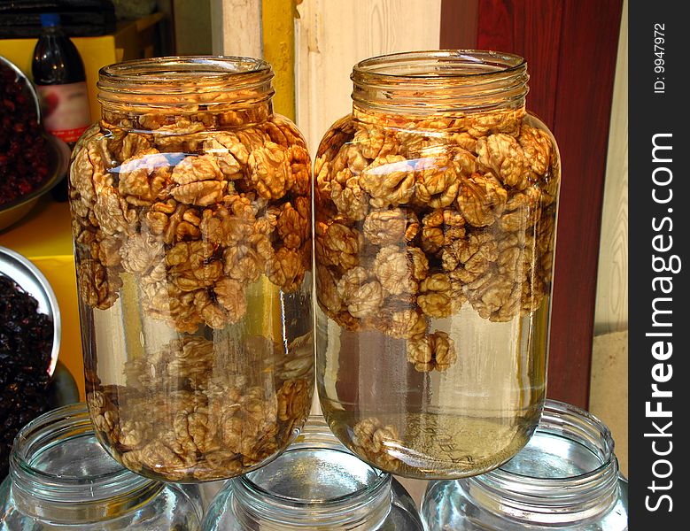 Peeled walnuts in water in glass jars in a street