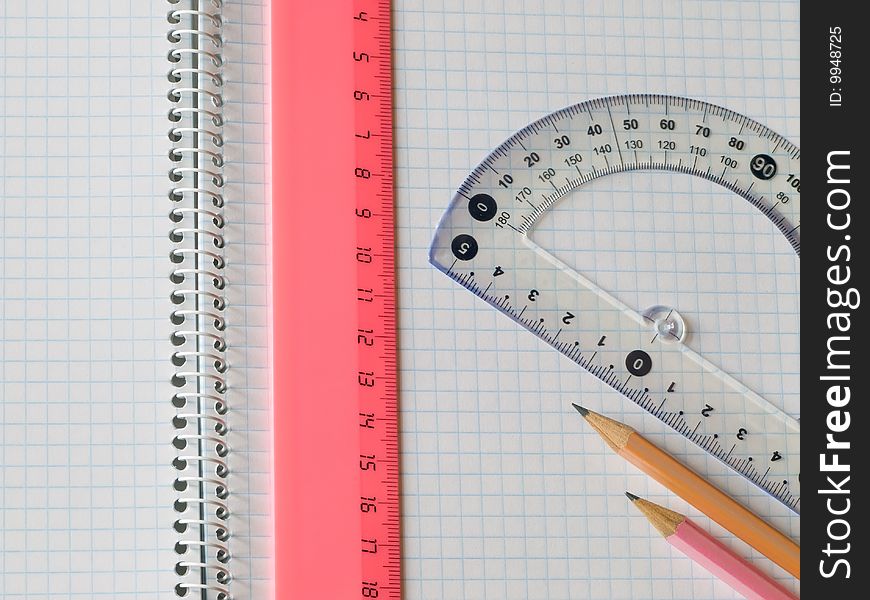 Ruler and pencils on squared sheet of a copybook. Ruler and pencils on squared sheet of a copybook