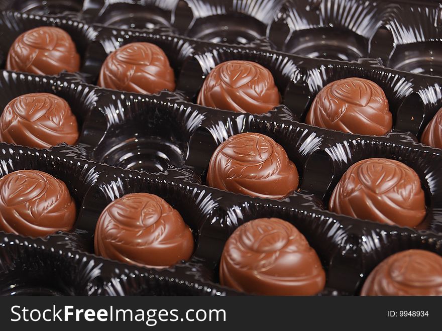 Chocolates in a box of black colour. A dessert.